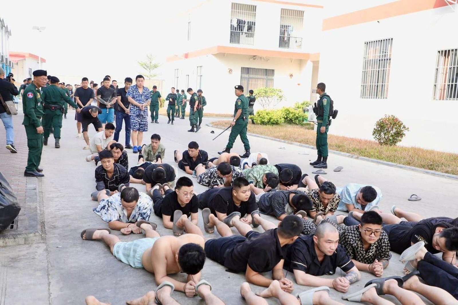 Suspected scam operators lie face down as part of security procedures during the operation, which resulted in the detention of over 2,000 foreign nationals.